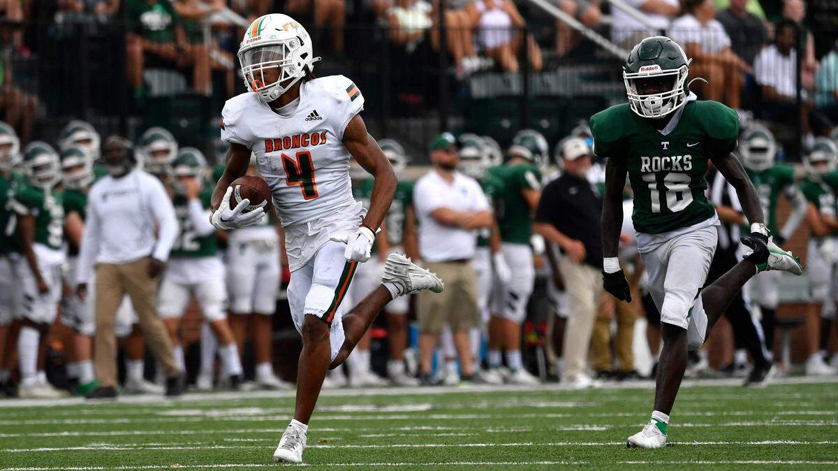 Frederick Douglass’ Derion Talbert (4) is pursued by Trinity’s Sekou Kamara on his way to the end zone during the second half of their game Saturday in Louisville.