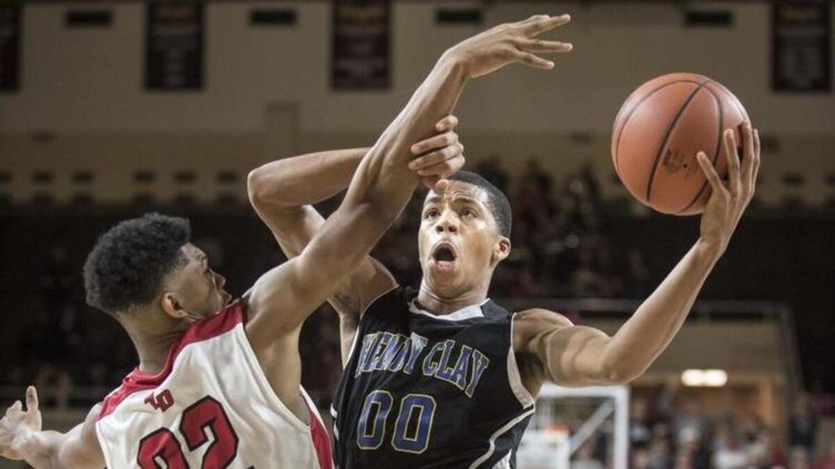 Henry Clay's Isaiah Tisdale (00) shoots around Dunbar's Tre Homer (22), during the semifinals of the boys 11th Region tournament, Saturday, March 5, 2016, at EKU's McBrayer Arena in Richmond.