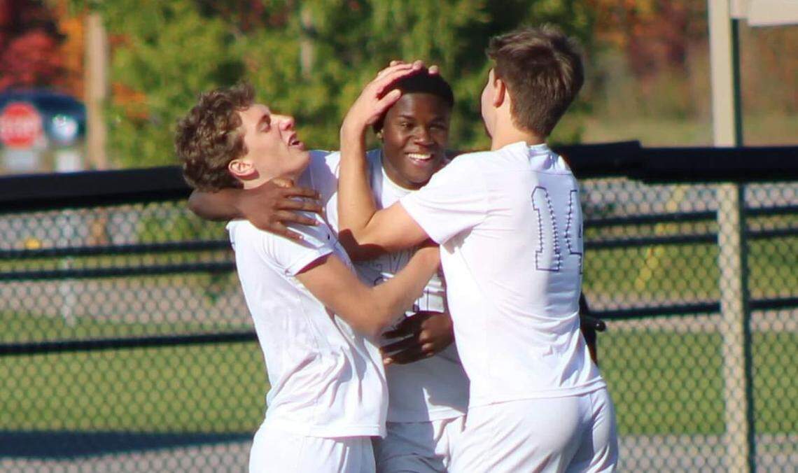 Henry Clay’s Marco Messerli, left, and Elliot Tiennot, right, celebrate with Shukuru Hamisi after one of Hamisi’s goals against Campbell County in the quarterfinals of the boys state soccer tournament at Campbell County High School on Saturday.