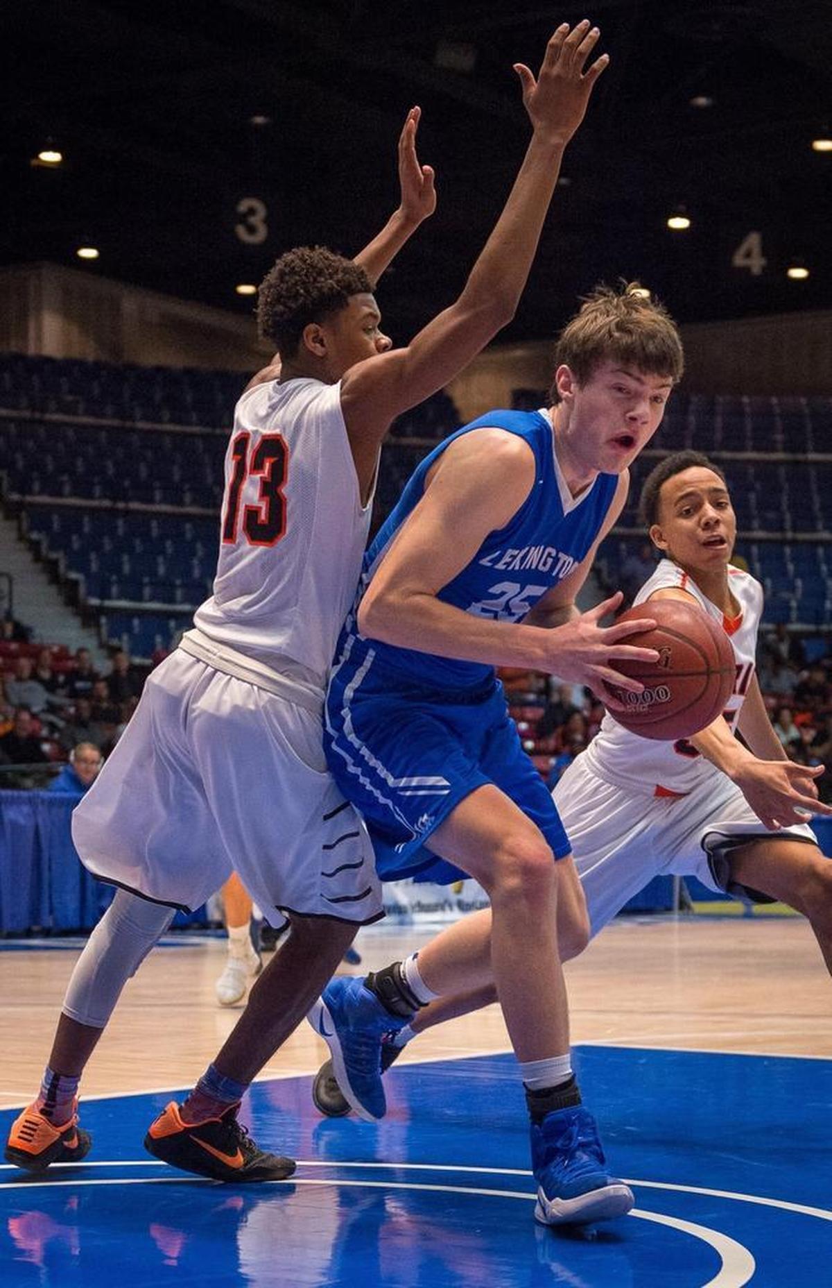 Lexington Christian's Austin Hall drives past Paris' Marcus Ashford during the semifinal game of the All "A" Tournament at the Frankfort Convention Center in Frankfort, Kentucky.