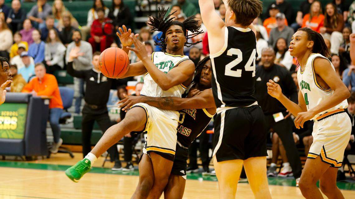 Bryan Station’s Amari Owens, left, gets fouled by Frederick Douglass’ Aveion Chenault as he drives into the lane in the first half of their game at Bryan Station High School on Friday.