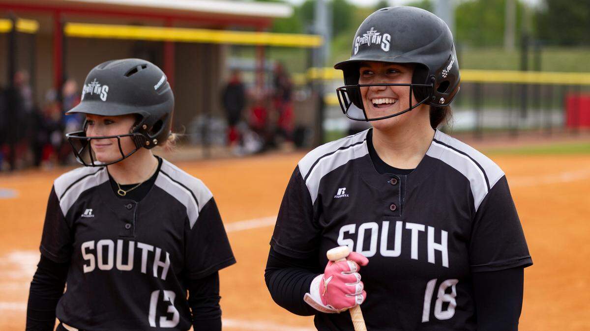 South Warren’s Layla Ogden (18) bantered with some Spartans fans along with teammate Jenna Lindsey (13) as they prepared for an at-bat at Scott County High School on April 26. Ogden tied the state’s single-season home run record of 24 this year.