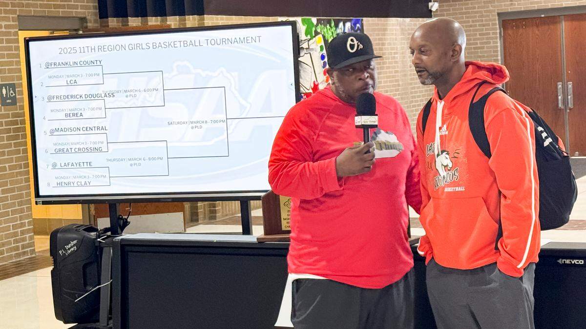Ozon Mitchell of “Big Things Kentucky on YouTube,” left, interviews Frederick Douglass girls basketball coach Daryl Moberly after the 11th Region Tournament draw at Paul Laurence Dunbar High School on Saturday.
