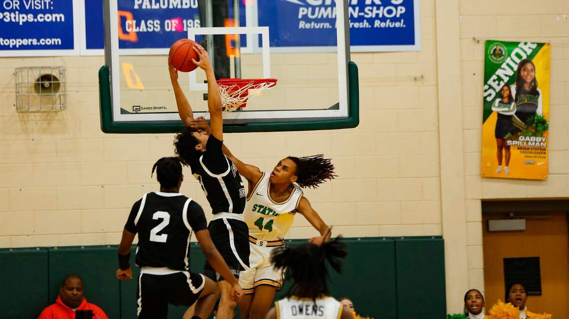 Frederick Douglass guard DeMarcus Surratt dunks over Bryan Station’s Antowone Burton early in the first quarter of their game at Bryan Station High School on Friday.