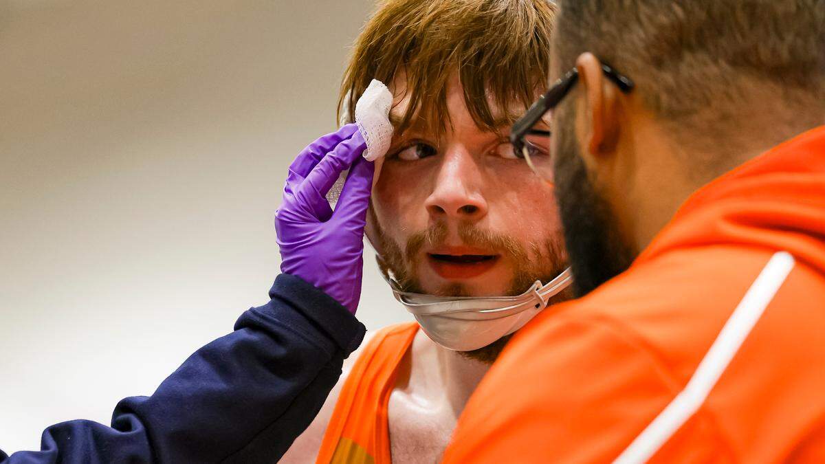 A trainer attends to a cut suffered by Frederick Douglass’ Landon Worley during a stoppage in his 165 division finals at the Boys/Coed Region 6 Wrestling Championships at East Jessamine High School on Saturday.