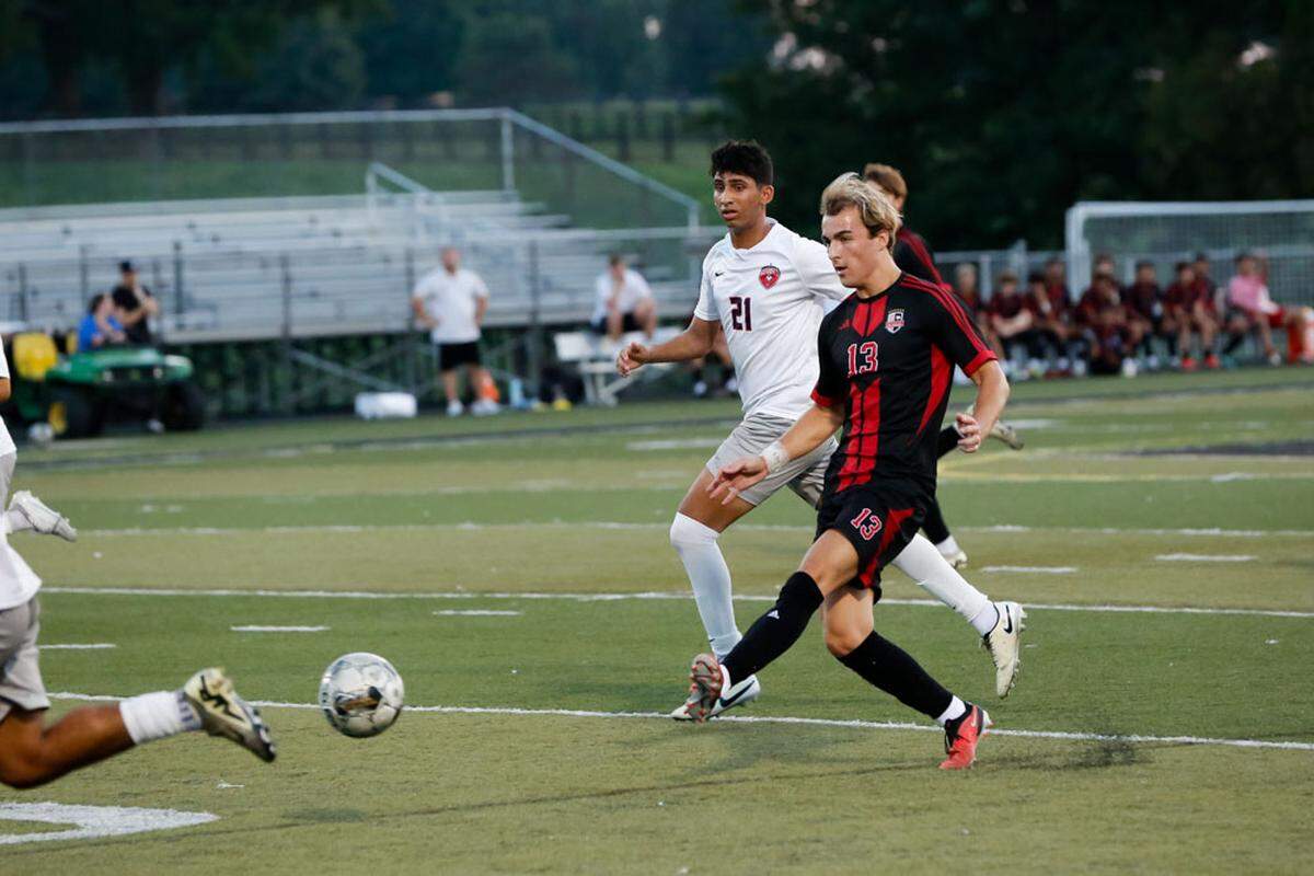 Paul Laurence Dunbar’s Chaz Rich (13) passes a ball forward while being trailed by Lafayette’s Mustafa Khan (21) during the Bulldogs’ 1-0 victory Tuesday night.