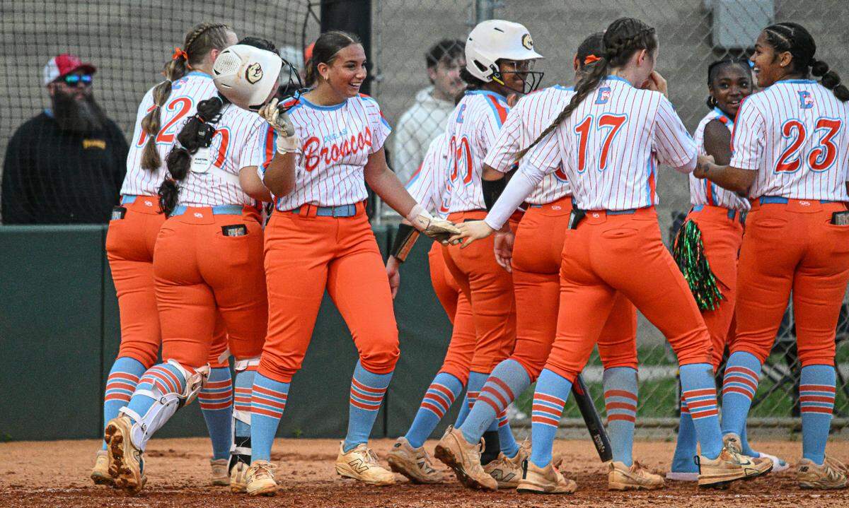 Frederick Douglass’ Riley Baker took her helmet off after celebrating her three-run home run at the plate with her teammates in the fifth inning of the Broncos’ 8-2 win against Scott County in the 42nd District Tournament championship game at Frederick Douglass on Wednesday.