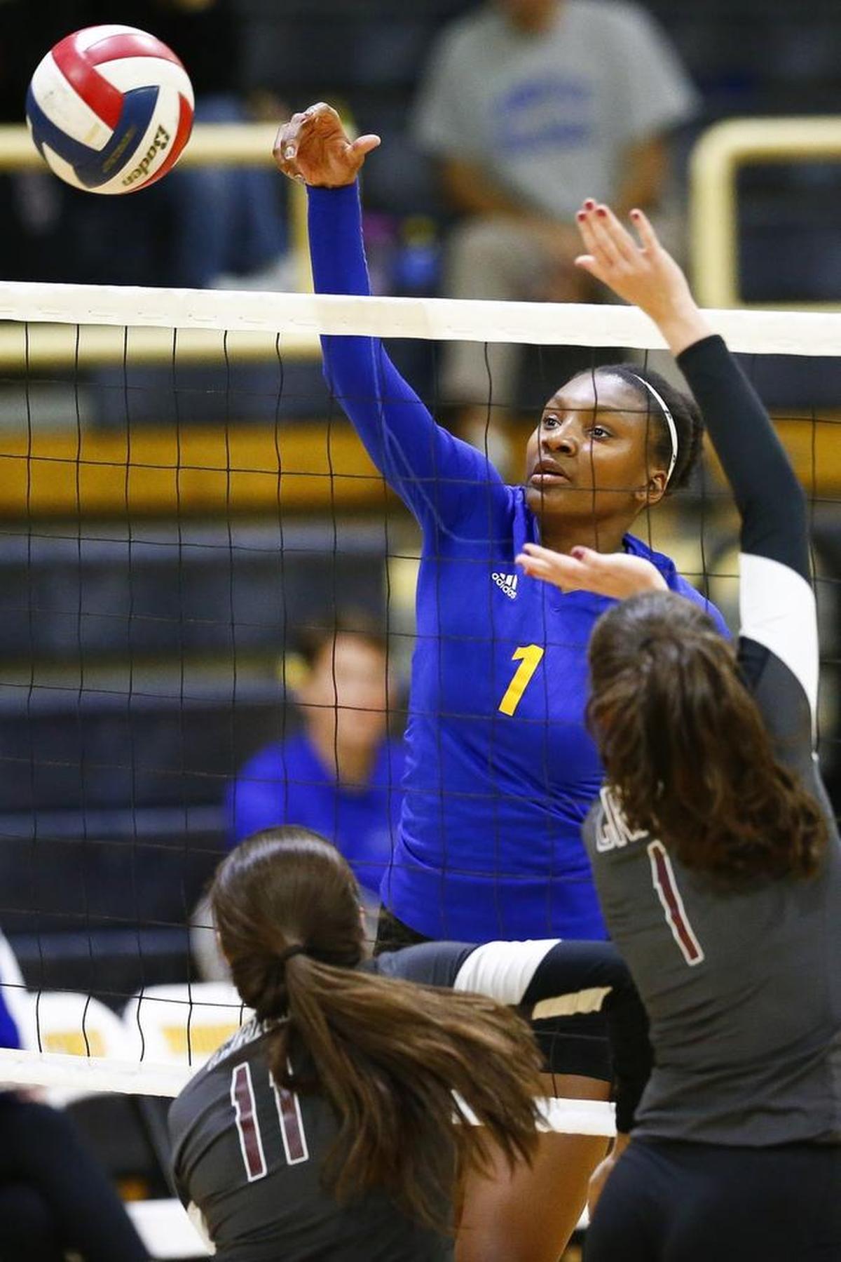 Henry Clay's Taylor Trammell (1) hits the ball past Tates Creek's Hannah Kazee (11) and Tates Creek's Claire Darland (1) during the 11th Region semifinals Woodford County High School in Versailles, Ky., Wednesday, Oct. 25, 2017.