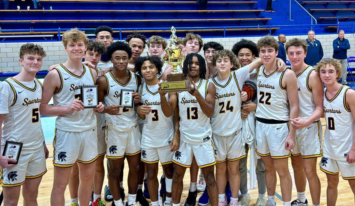 Sayre’s boys basketball team celebrates with its 11th Region All “A” Classic championship trophy after the Spartans defeated Berea 83-59 at Frankfort High School’s F.D. Wilkinson Gymnasium on Saturday.