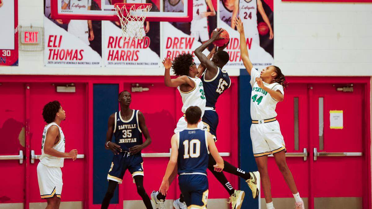 Danville Christian’s Leek Ateny (15) goes up for a shot between Bryan Station’s Taeshawn Adams (35) and Antowone Burton as teammate Lual Ayiei (25) and other players awaited the outcome in the Warriors 45-44 win over the Defenders in the Jock Sutherland Classic at Lafayette High School on Saturday.