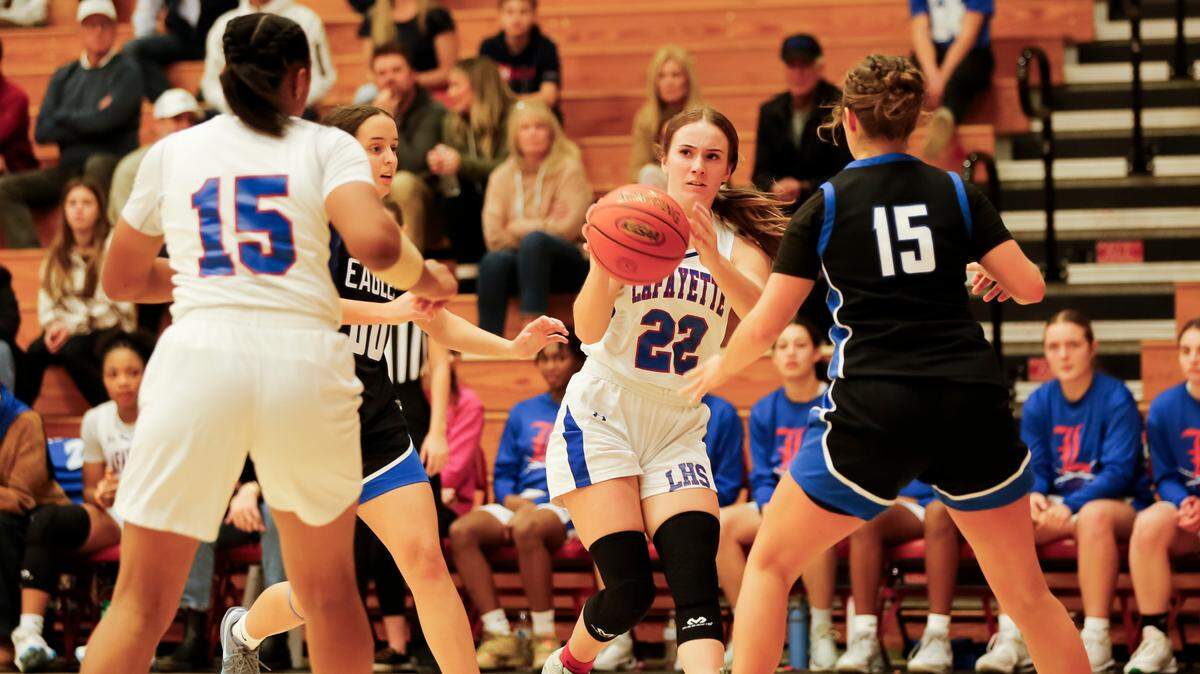 Lafayette point guard Anna Clay Denton (22) lines up a pass into the post for teammate Addi Combs, left, against the defense of Lexington Christian’s Piper Graham (00) and Chapel Brown, right, during the Generals’ 67-43 home win Friday.