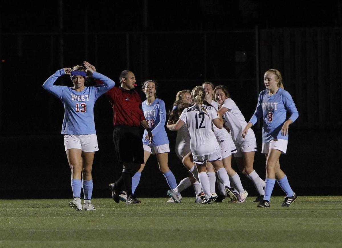 West Jessamine's Kami Yantz walks away as Sacred Heart celebrates the goal by Cassie Amshoff during the semifinals of the KHSAA girls' state soccer championship at Ishmael Stadium in Lexington, Ky., Thursday, November 2, 2017.