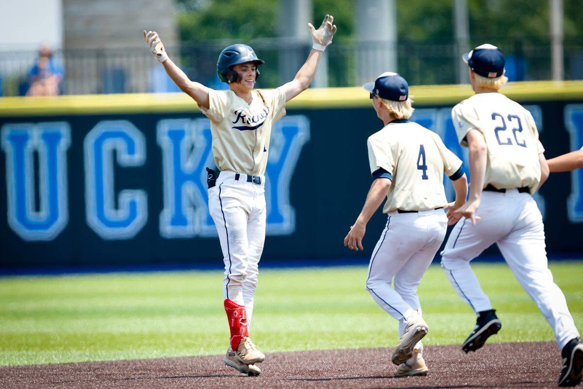 Shelby County’s Jack Wills throws his arms up in celebration as he is about to be swarmed by his entire team after his game-winning RBI single Friday that helped the Rockets beat Apollo 2-1 in the state baseball tournament semifinals at Kentucky Proud Park.