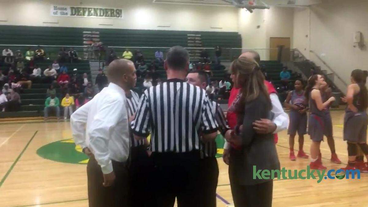 Bryan Station girls basketball Coach Shawn Ransom, left, and Lafayette Coach Allison Denton, right, huddled with officials Thursday as referees explained the double technicals and ejections being handed out after a brief confrontation between players in the second half. Nine players and managers who stepped onto the floor in the incident were ejected, but the players directly involved stayed in the game.