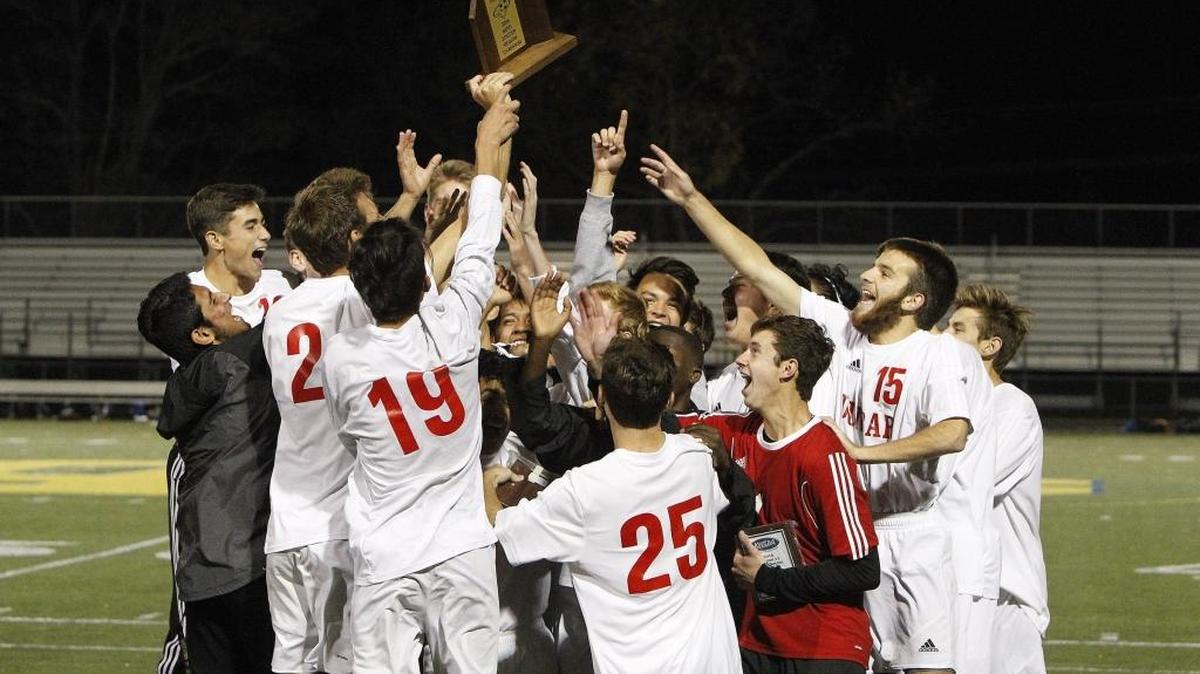 Paul Laurence Dunbar players hoist the 11th region championship trophy after defeating Woodford Co. at Henry Clay soccer field in Lexington, Ky., Saturday, October 22, 2016.