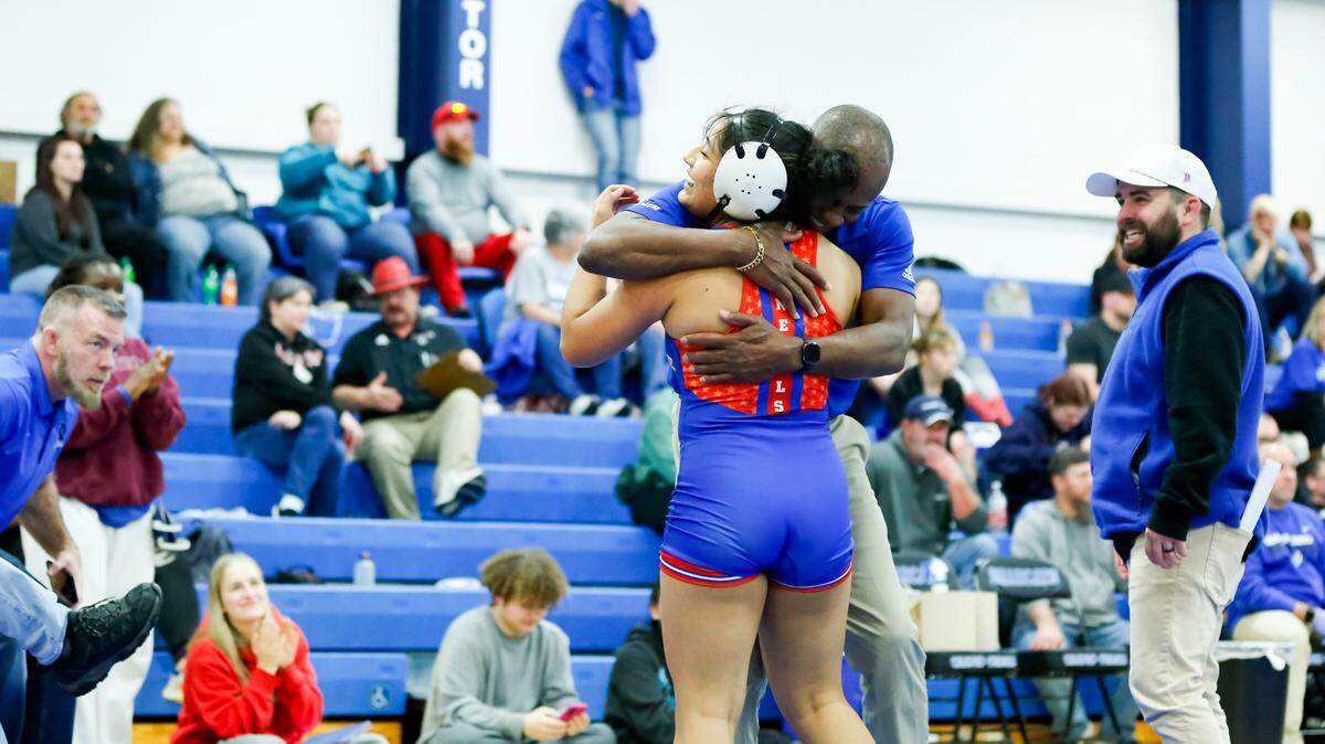 Lafayette’s Amy Velasco hugs coach William Green after her victory in the 145 division of the Girls Region 8 Wrestling Championships at Walton-Verona High School in Walton on Saturday.