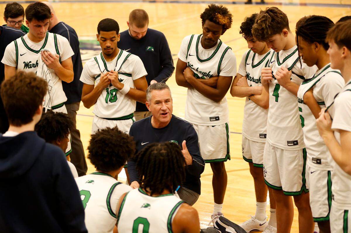 Great Crossing coach Steve Page, center, spoke to his team during the break between the first and second periods in the Warhawks’ 59-50 win against the Juggernauts at Great Crossing High School in Georgeown on Saturday.