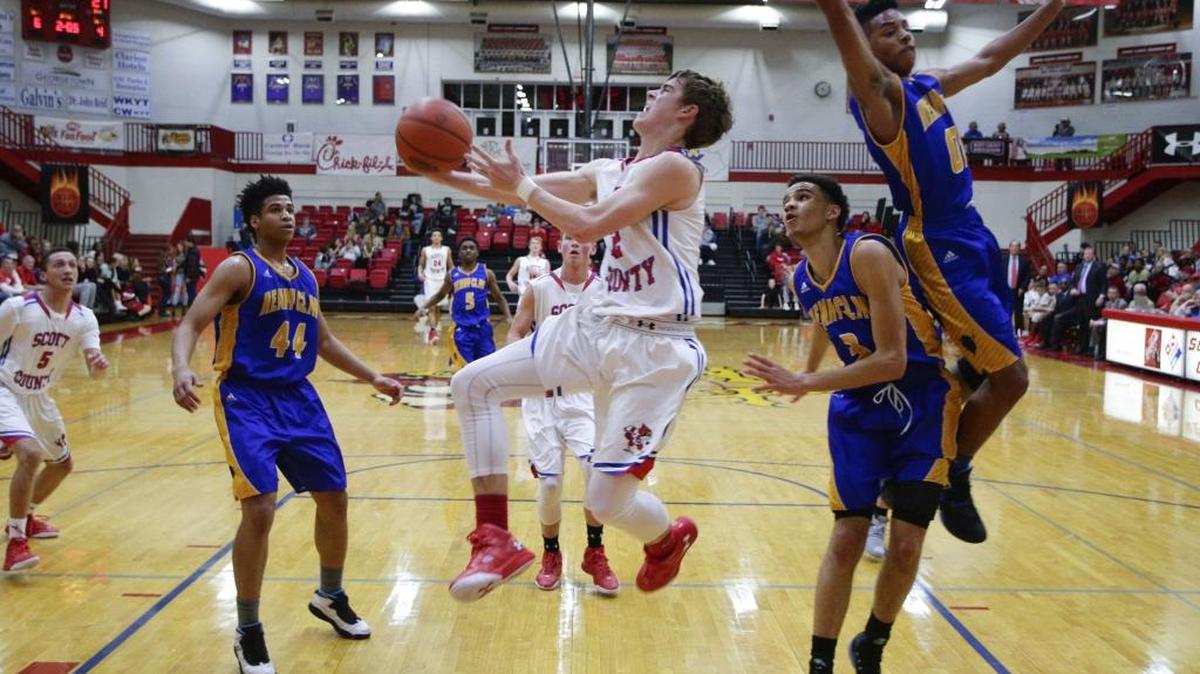 Scott County's Bryce Long, went under Isaiah Tisdale, right, and Leander Ridgeway, 3, for two points as Scott County defeated Henry Clay 74-69 on Friday February 5, 2016 in Georgetown, Ky.
