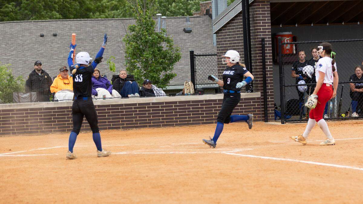 Lexington Catholic’s Aevea Mosley-Franklin signals that teammate Kayla Mattingly can come home standing up after a passed ball allowed the Knights to take a 2-0 lead in the fourth inning of the 43rd District Tournament softball championship at Tates Creek on Thursday.