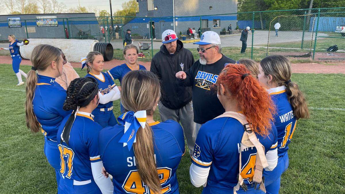 Henry Clay Coach Timothy McCoy, at center, right, speaks to his varsity softball starters after the Blue Devils’ 12-5 home win over Tates Creek on Monday.