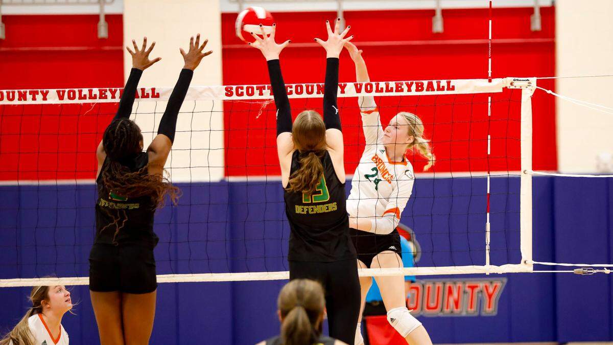 Frederick Douglass outside hitter Addison Jarvis (24) goes for a kill against Bryan Station’s Micah Robinson, left, and Ashley Deters (13) in their 42nd District volleyball tournament semifinals game at Scott County High School in Georgetown on Tuesday.