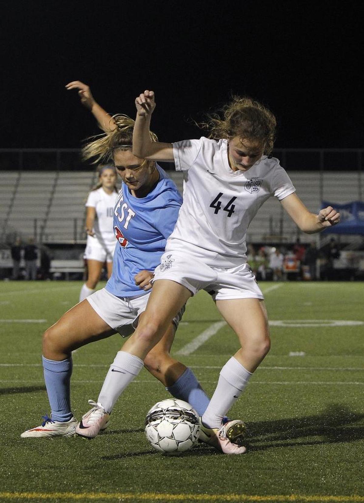 Sacred Heart's Brielle Heuglin battles against West Jessamine's Sophie Bish during the semifinals of the KHSAA girls' state soccer championship at Ishmael Stadium in Lexington, Ky., Thursday, November 2, 2017.