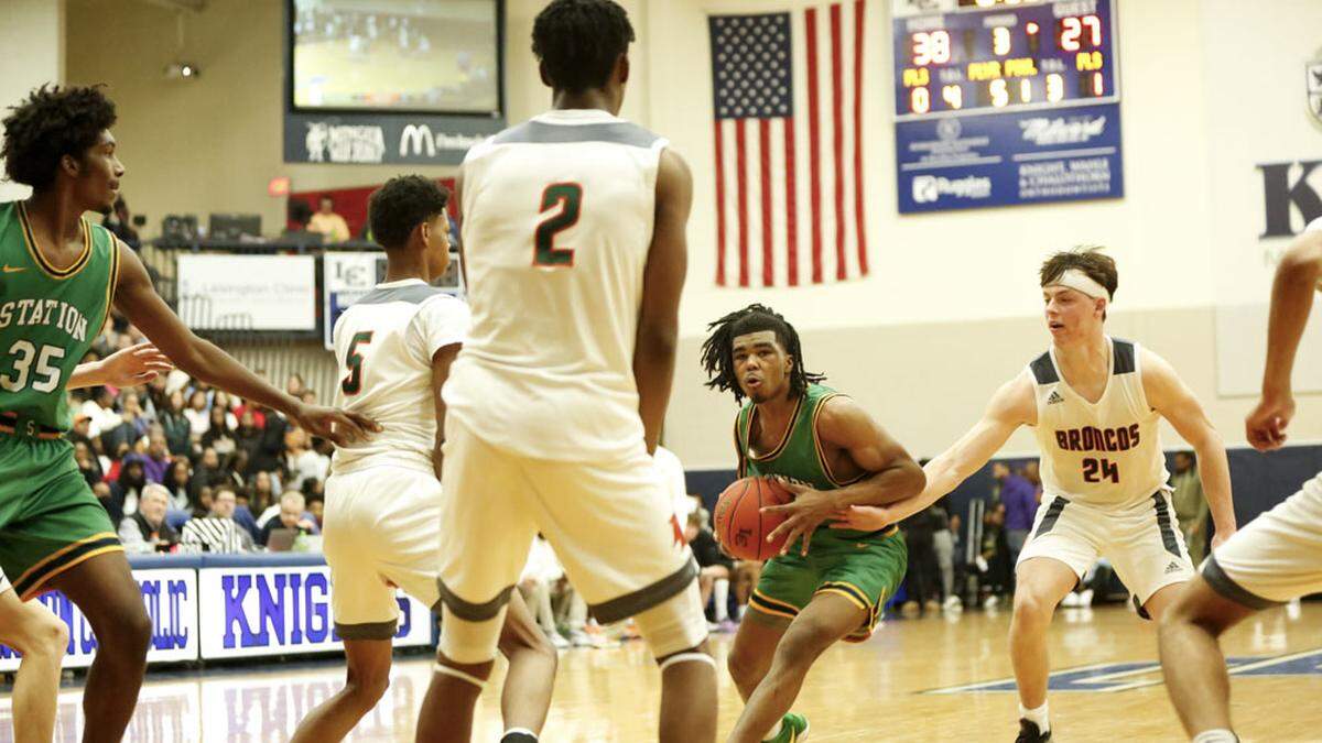 Bryan Station point guard Amari Owens, center, looks for a way through Frederick Douglass’ defense, which included Travis Jones (5), Jaunte Jenkins (2) and Logan Busson (25) during the White, Greer & Maggard Holiday Classic championship game at Lexington Catholic on Monday.