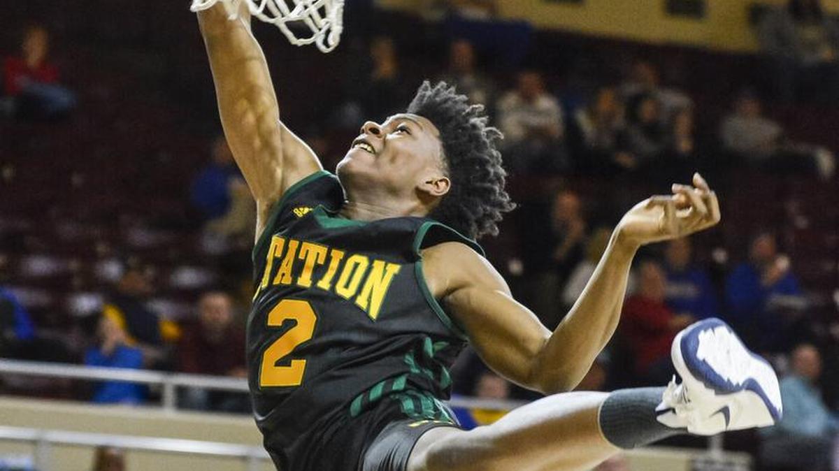 Bryan Station's Deandre Dishman dunks over Madison Central, during the opening round of the boys 11th Region Tournament, Saturday morning, March 7, 2015, at McBrayer Arena in Richmond.