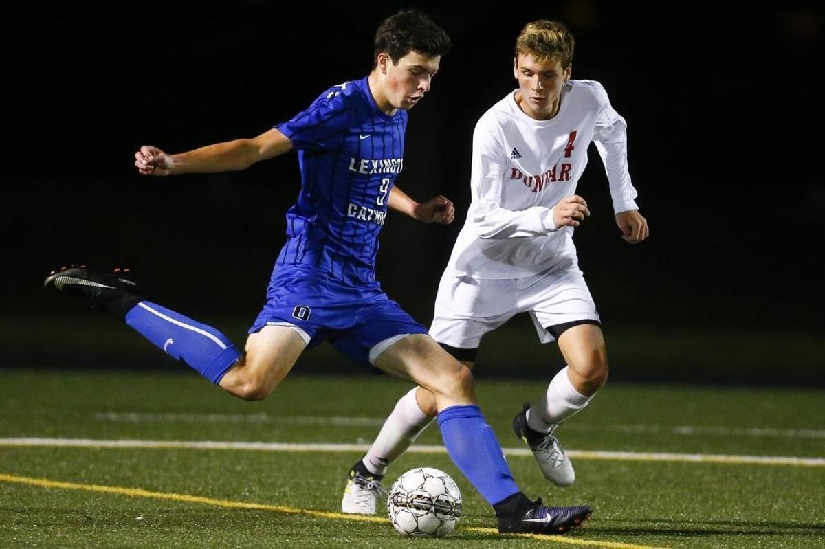 Lexington Catholic's Brian Banahan (9) kicks the ball past Paul Laurence Dunbar's Jake Heil (4) during the 43rd District finals at Paul Laurence Dunbar High School in Lexington, Ky., Thursday, Oct. 12, 2017. Lexington Catholic beat Paul Laurence Dunbar 2-1 on penalty kicks.
