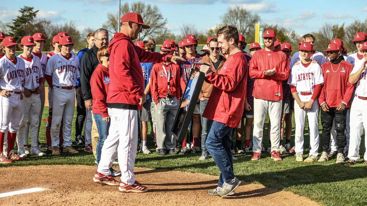 Lafayette baseball coach Chris Langston, left, receives a commemorative framed jersey and plaque marking his 600th win presented by his son, Drew Langston, on behalf of the program. Langston earned his 600th career victory as a coach last weekend.