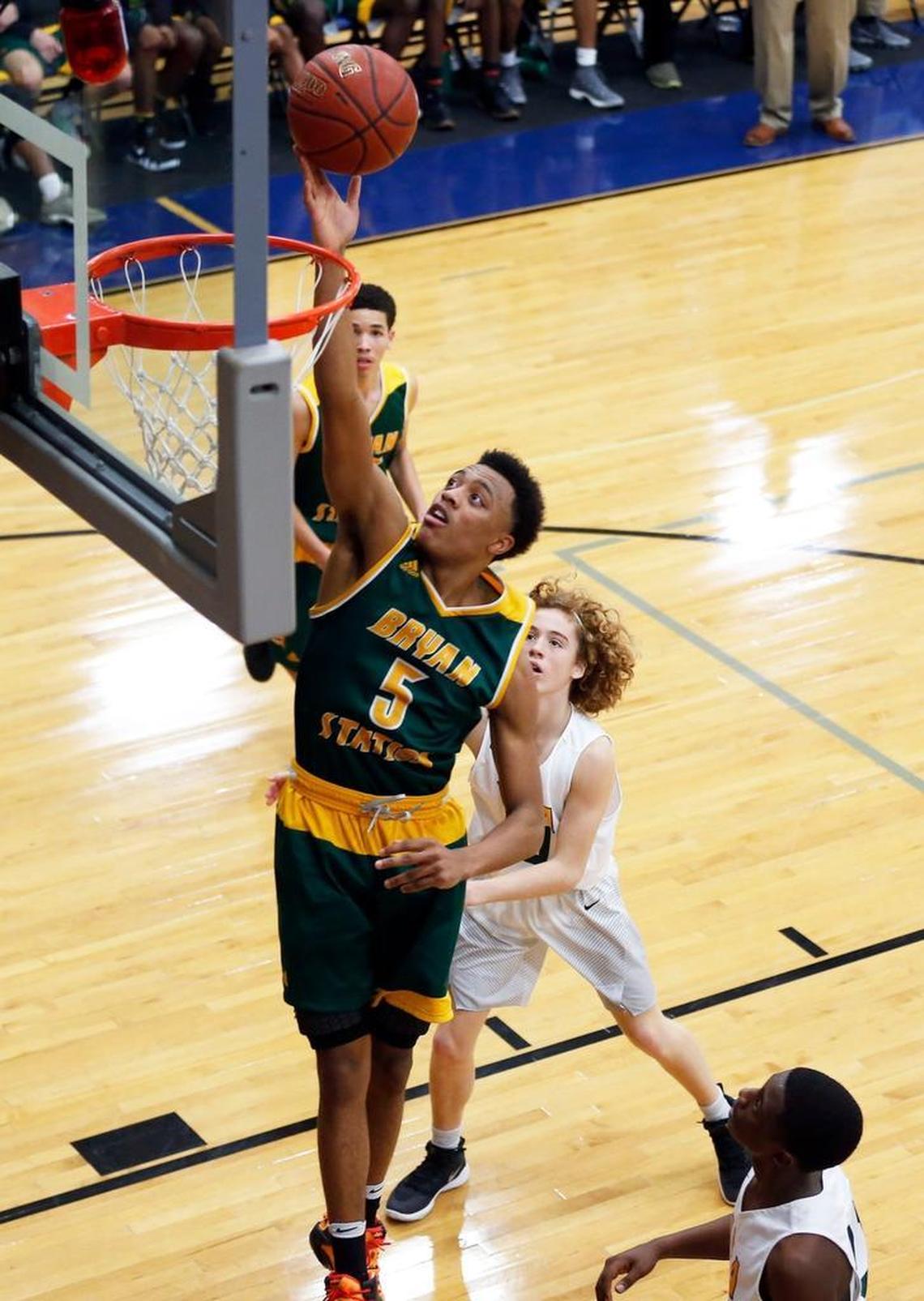 Bryan Station’s Eric Boone scored on a drive past University Heights’ William Bryan during their game in December.