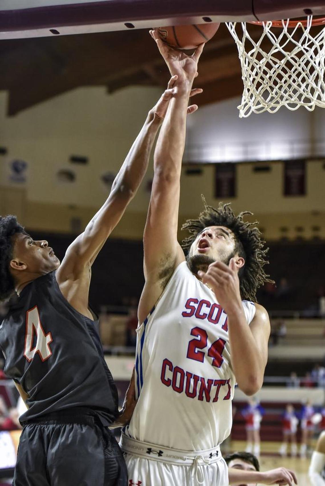Scott County's Michael Moreno (24) scores two of his 29 points in the first half over Madison Southern's Josh Reynolds (4), during the first round of the 11th Region tournament, Thursday night, March 1, 2018, at EKU's McBrayer Arena in Richmond.