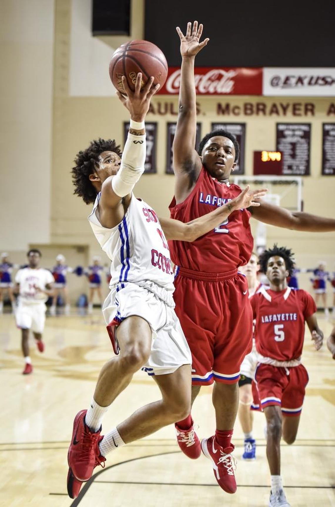 Scott County's Diablo Stewart (11) drives past Lafayette's Evan Dreux (2), during the semi finals of the boys 11th Region tournament, Saturday, March 3, 2018, at EKU's McBrayer Arena in Richmond.