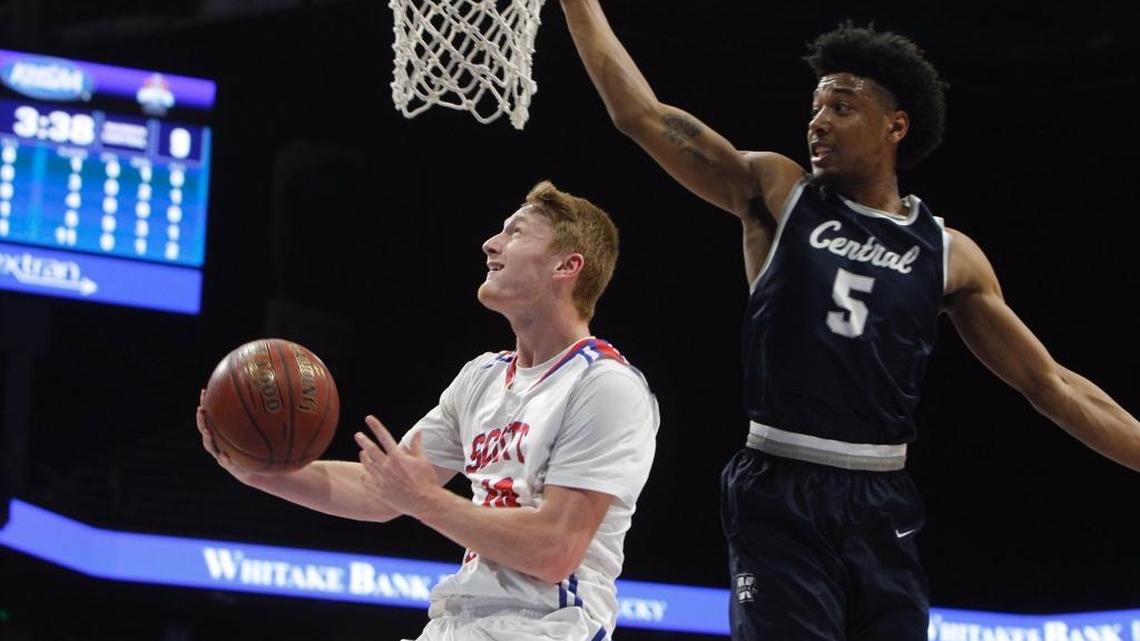 Scott County senior Cooper Robb, left, went up for a layup with Warren Central’s Skyelar Potter (5) pressuring during the semifinals of the 101st Whitaker Bank/KHSAA Boys’ Sweet Sixteen on Saturday, March 17, 2018, at Rupp Arena in Lexington, Kentucky.