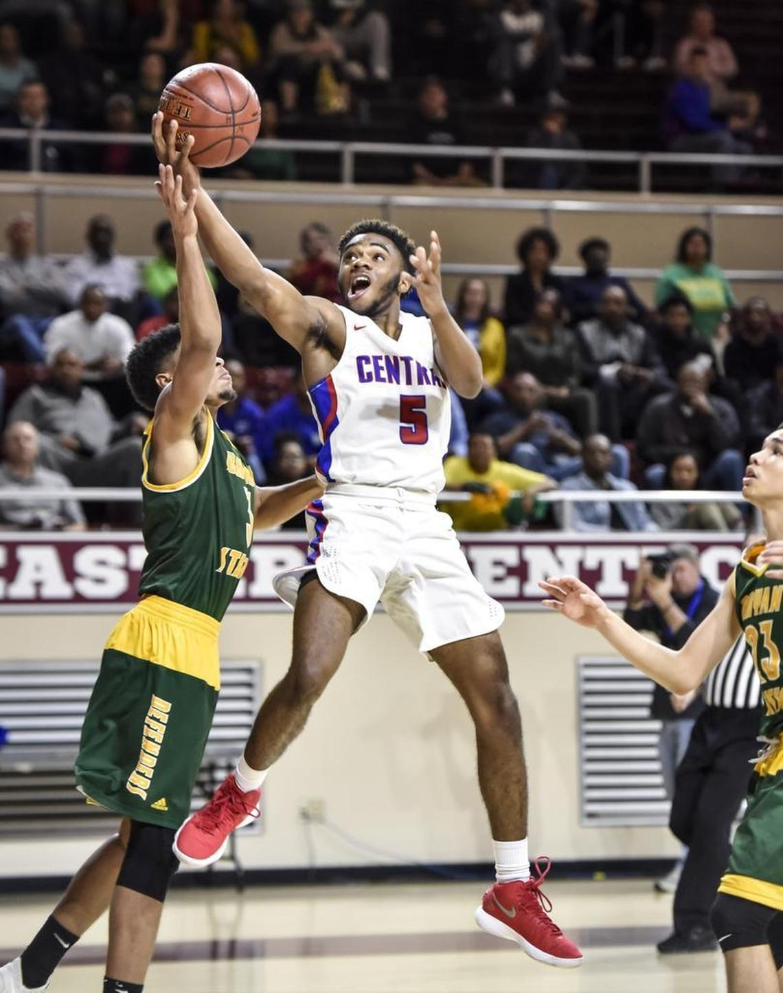 Madison Central's Isaiah Minter (5) shoots over Bryan Station's Jalen Burbage (3), during the first round of the 11th Region tournament, Wednesday night, February 28, 2018, at EKU's McBrayer Arena in Richmond.
