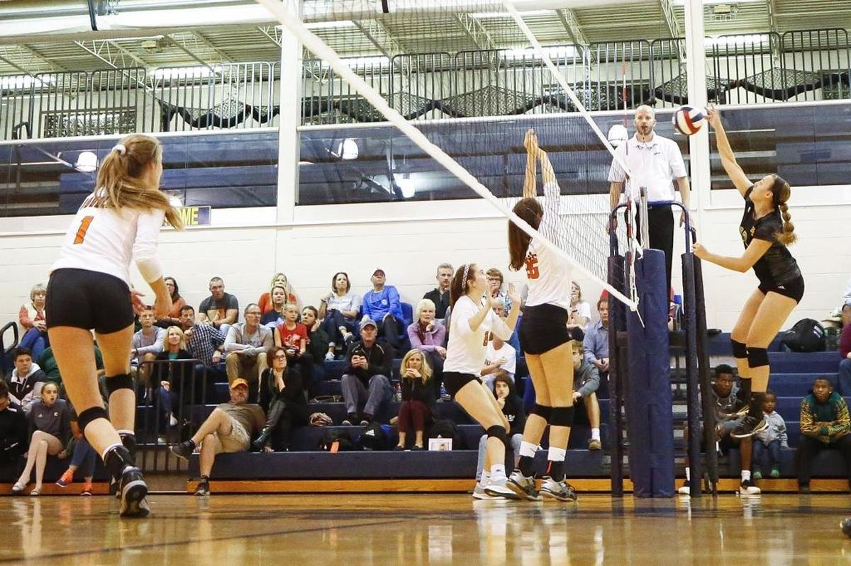 Bryan Station's Danielle Puckett (12) hits the ball past Frederick Douglass' Kirsten Mason (8) and Frederick Douglass' Lauren Reynolds (26) during their 42nd District tournament semifinal game at Sayre in Lexington, Ky., Wednesday, Oct. 18, 2017. Bryan Station beat Frederick Douglass 3-0.