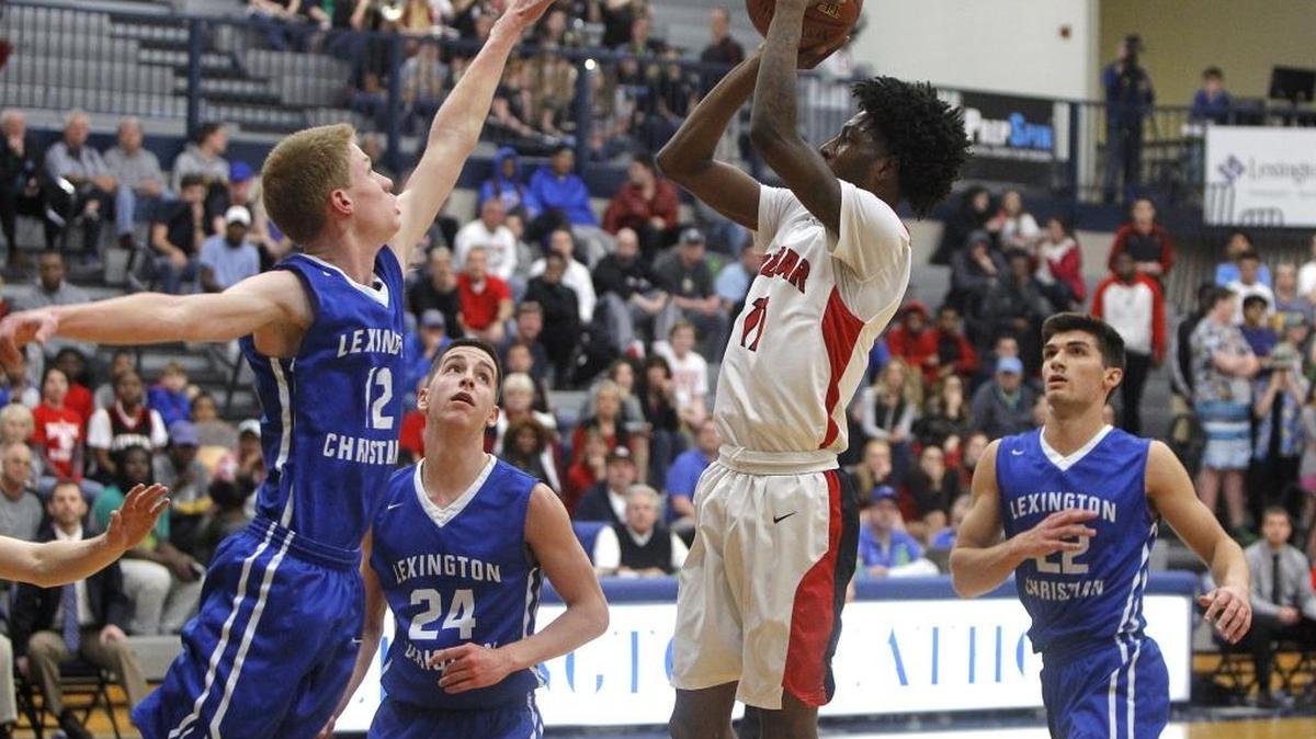 Paul Laurence Dunbar's Taveion Hollingsworth shoots against Lexington Christian Academy's Will Hacker during the semifinals of the 43rd district tournament in the Beuter Gymnasium in Lexington, Ky., Tuesday, February 21, 2017.