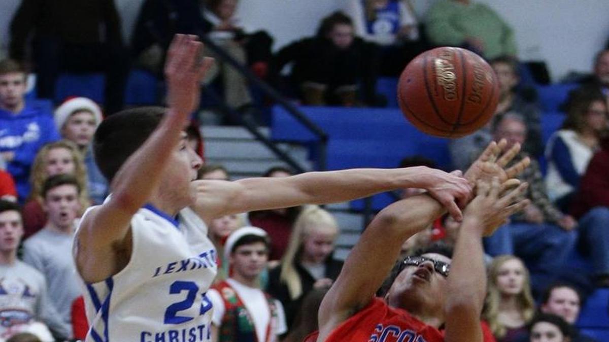 LCA's Nathan Harper fouled Scott County's Lorenzo Williams, on a drive to the basket as LCA played Scott County on Thursday December 7, 2016 in Lexington, Ky.