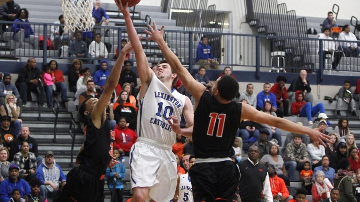 Lexington Catholic's Luke Johnson shoots against Paris' Ryan Davis and Eric Johnson during the semifinals of the boys' Traditional Bank Holiday Classic in the Beuter Gymnasium at Lexington Catholic in Lexington, Ky., Thursday, December 29, 2016.