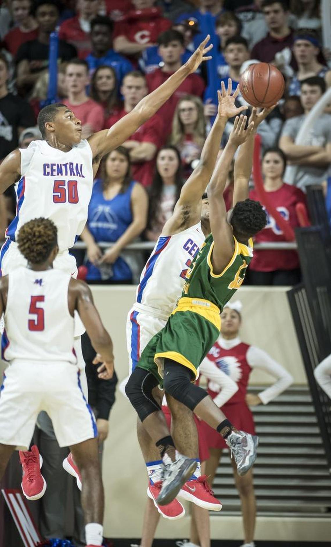Madison Central's Isaiah Cozart (50), left, blocks the shot of Bryan Station's James Lindsay (13), during the first round of the 11th Region tournament, Wednesday night, February 28, 2018, at EKU's McBrayer Arena in Richmond.