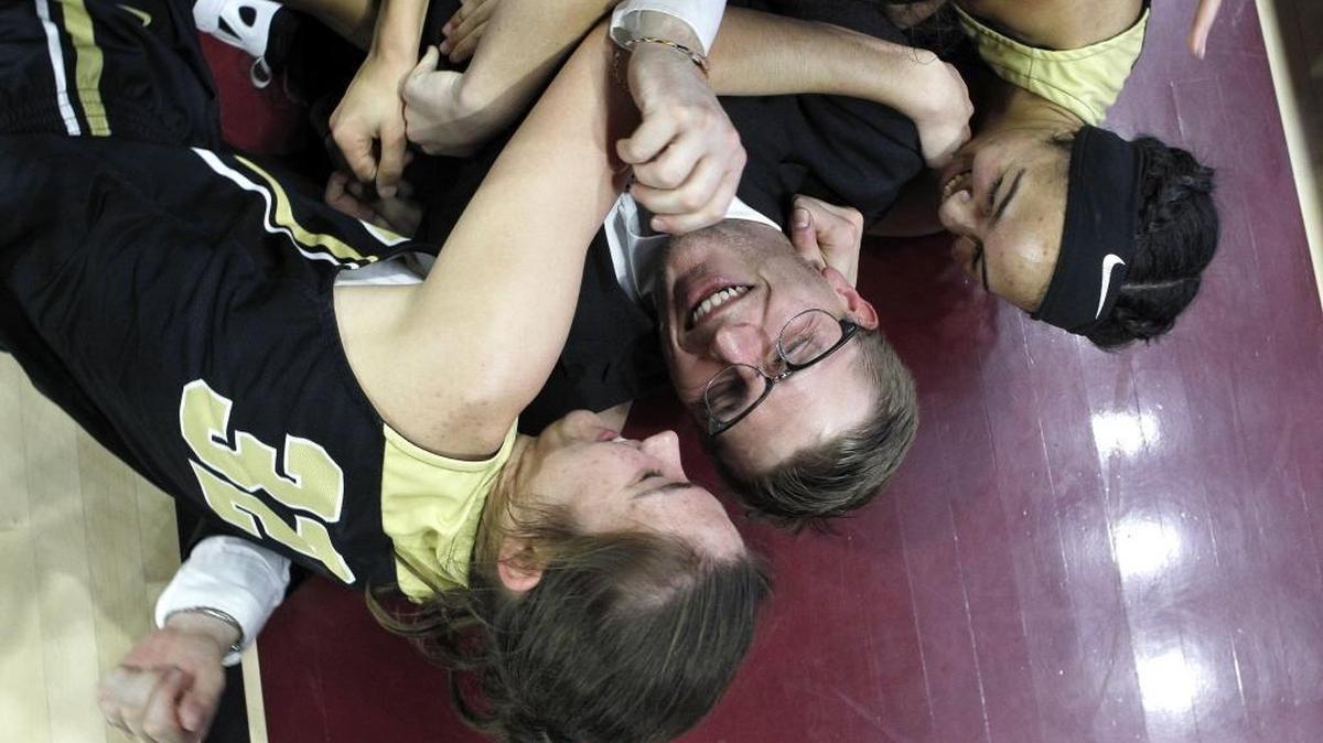 Murray's Alexis Burpo and Elizabeth Curtis knocked coach Wyatt Foust to the floor as they celebrated after defeating Shelby Valley to win the girls' All 'A' Classic championship at Alumni Coliseum in Richmond, Ky., Sunday, January 28, 2018.