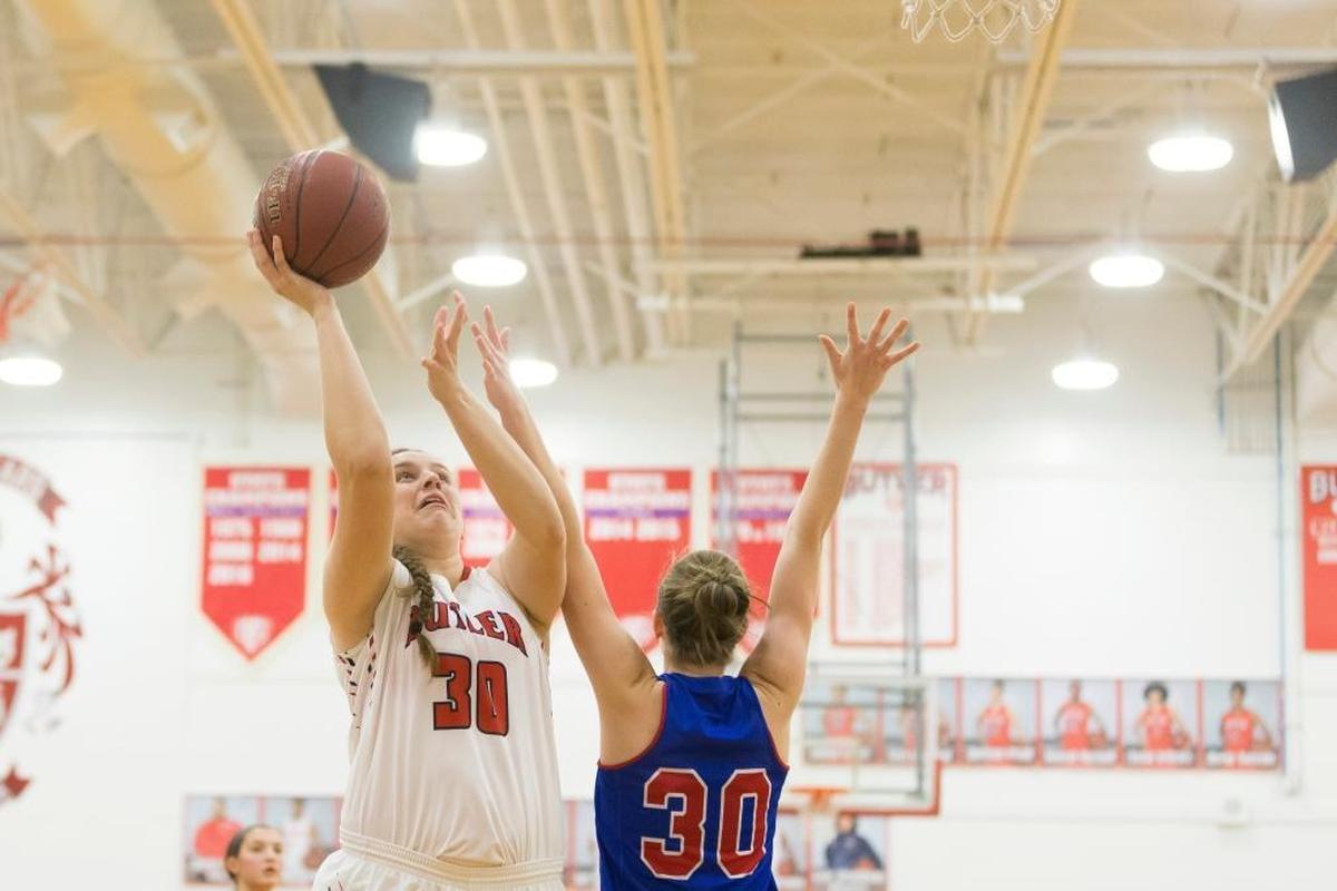 Butler center Molly Lockhart (30) shoots the ball under pressure from Mercer County Titans forward Emma Souder (30) during the Girls Basketball game between Mercer County and Butler at Butler high school in Louisville, Ky.
