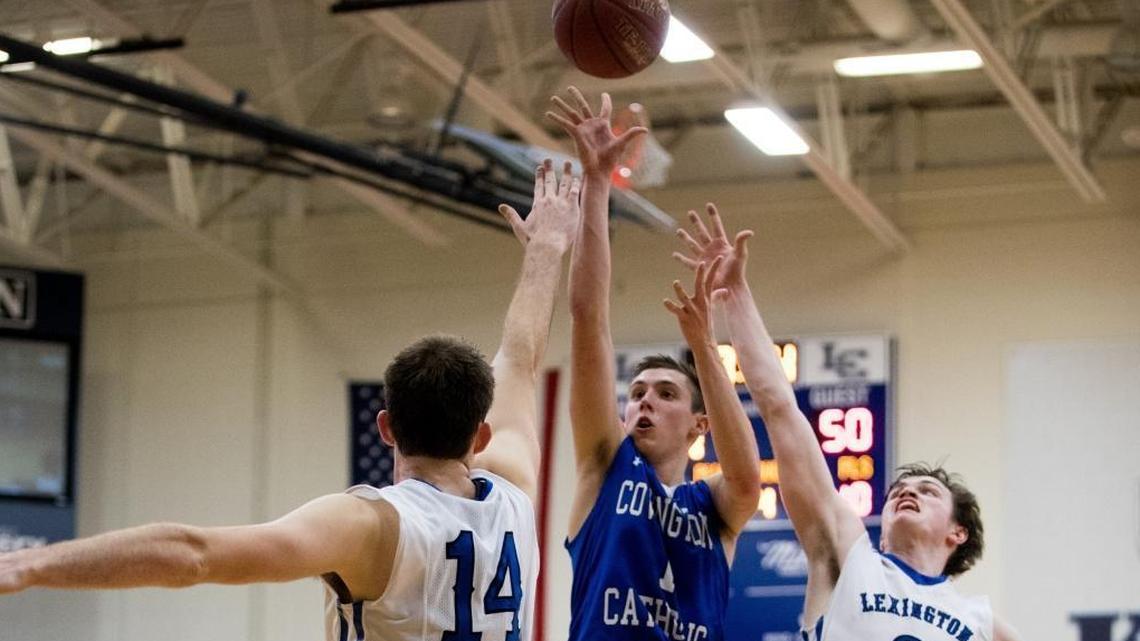 Covington Catholic's CJ Fredrick (1) shot over Lexington Catholic's Max Sparkman (14) and TC Price (3) as host Lexington Catholic came up short 54-53 against Covington Catholic on Wednesday Nov. 29, 2017 in Lexington, Ky.