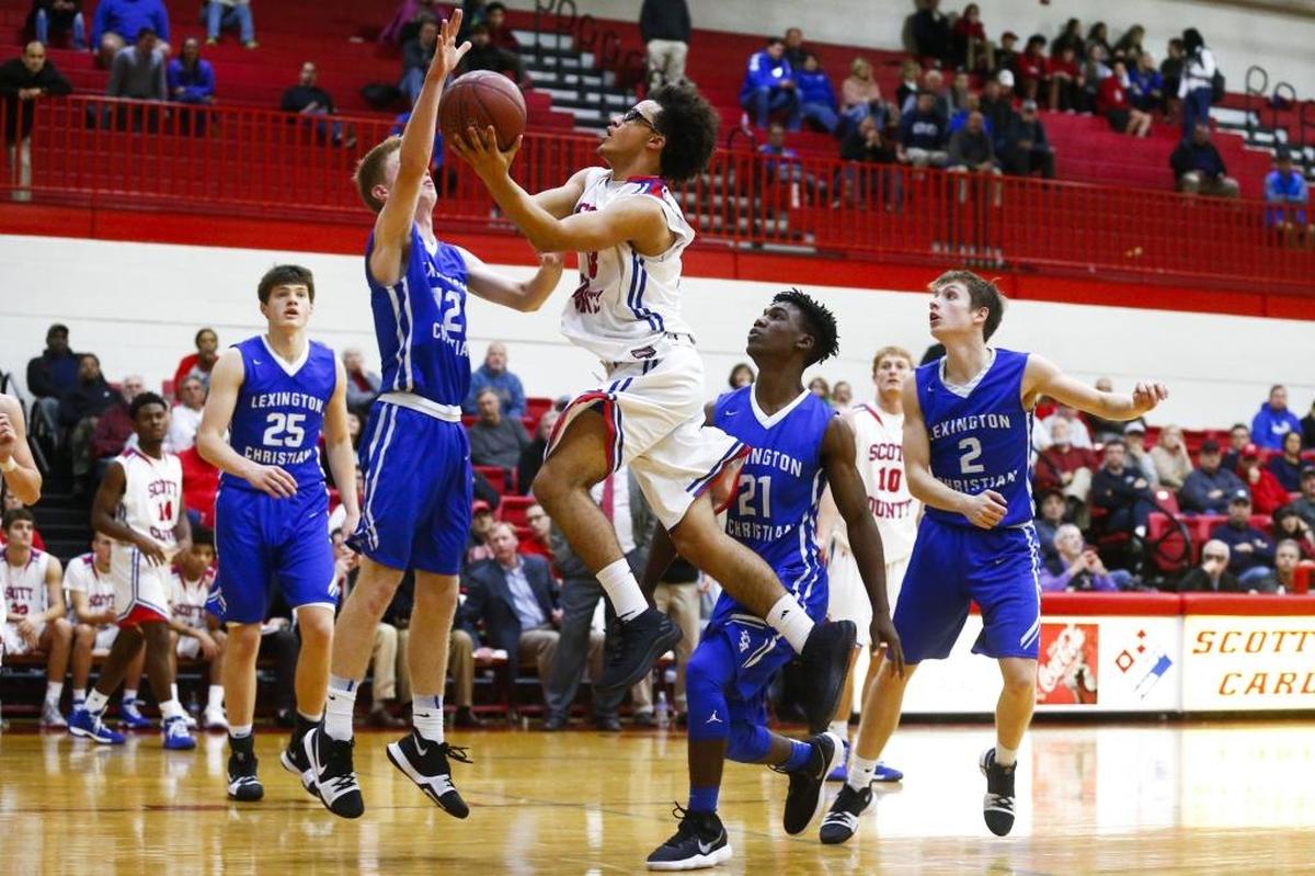 Scott County's Lorenzo Williams (33) goes to the hoop against Lexington Christian's Will Hacker (12) and Lexington Christian's Isaiah Hunt (21) during their game at Scott County High School in Georgetown, Ky., Thursday, Dec. 7, 2017. Scott County beat Lexington Christian 68-59.
