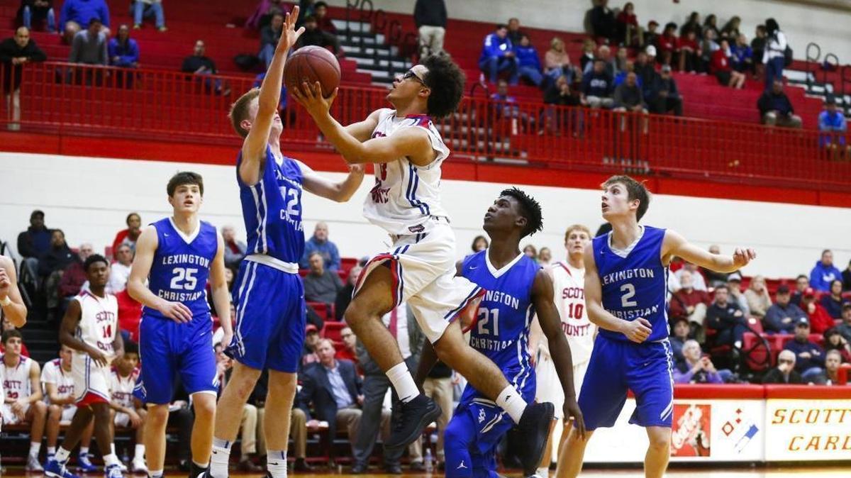 Scott County's Lorenzo Williams (33) goes to the hoop against Lexington Christian's Will Hacker (12) and Lexington Christian's Isaiah Hunt (21) during their game at Scott County High School in Georgetown, Ky., Thursday, Dec. 7, 2017. Scott County beat Lexington Christian 68-59.