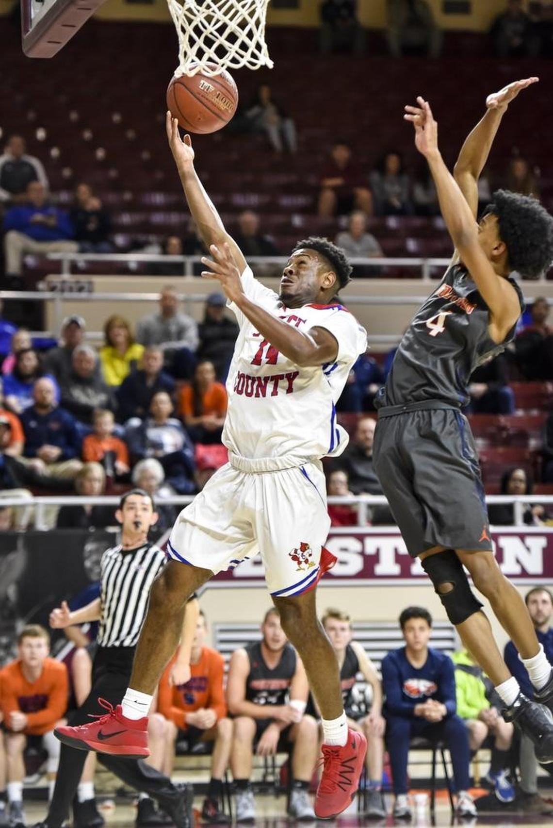 Scott County's Glenn Covington (14) shoots over Madison Southern's Josh Reynolds (4), during the first round of the 11th Region tournament, Thursday night, March 1, 2018, at EKU's McBrayer Arena in Richmond.