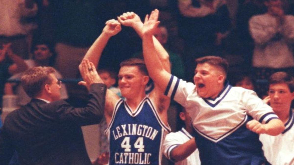 Coach Danny Haney (left in suit) celebrated Lexington Catholic's 11th Region boys' basketball title with Pat Deters (center, arms high in air) and Brandon Salsman (right, next to Deters, arm up) on March 17, 1992. Photo published on March 18, 1992.