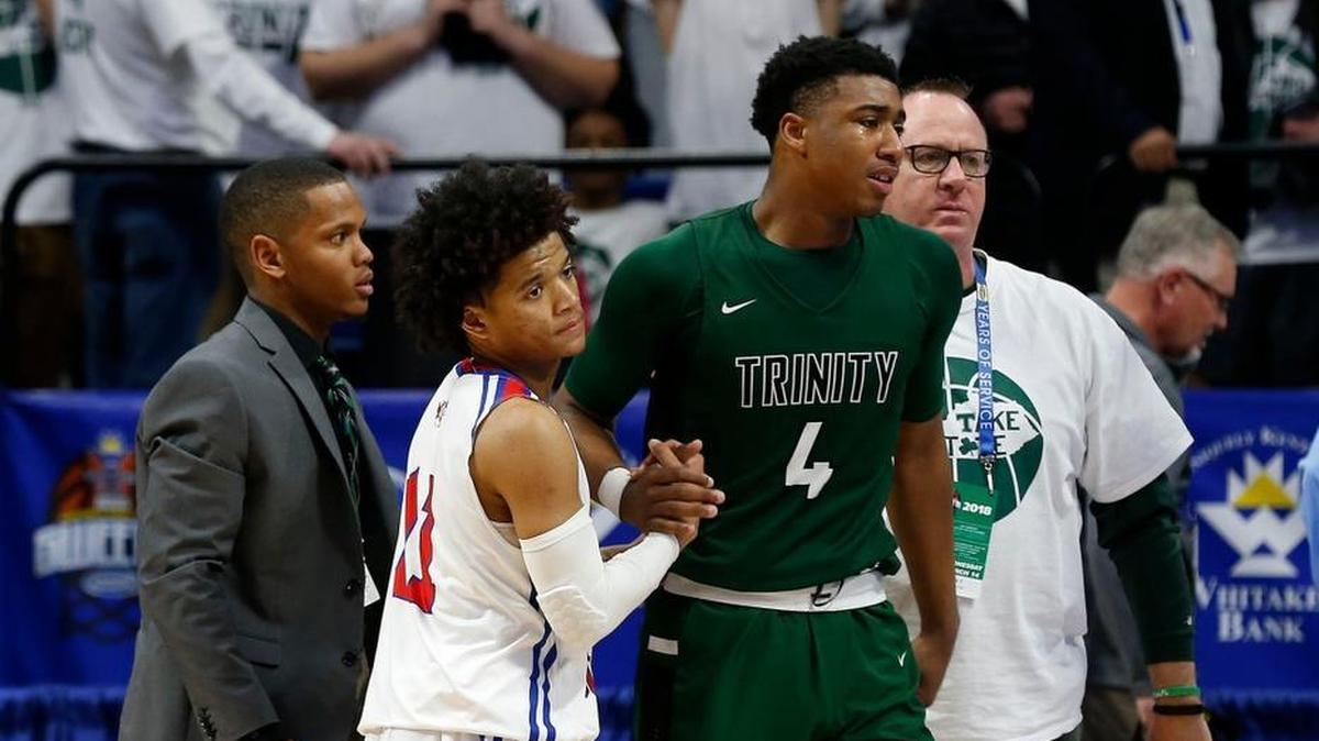 Scott County's Diablo Stewart helped Trinity's Jay Scrubb off the floor after Scott County defeated Trinity in an opening round game at the 101st Whitaker Bank/KHSAA Boys' Sweet Sixteen state basketball tournament being played Wednesday at Rupp Arena in Lexington. This is fourth quarter action. Scott Co. won 54-53.