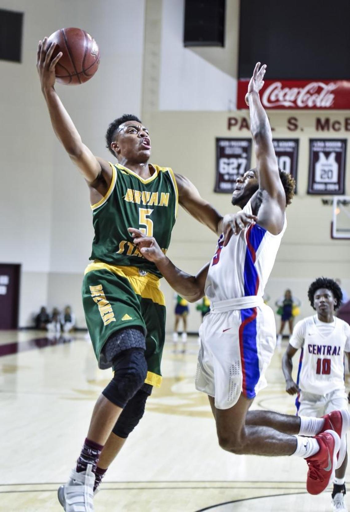 Bryan Station's Eric Boone (5) shoots over Madison Central's Isaiah Minter (5), during the first round of the 11th Region tournament, Wednesday night, February 28, 2018, at EKU's McBrayer Arena in Richmond.