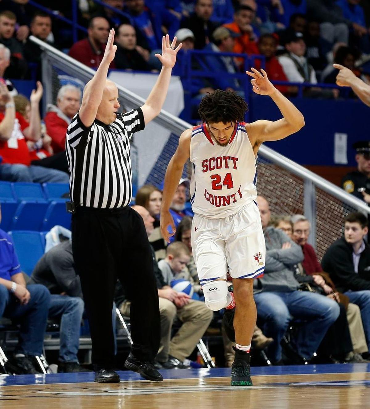 Scott Co.'s Michael Moreno (24) celebrated a three-pointer for the first points of the gameas Scott County played Trinity in an opening round game at the 101st Whitaker Bank/KHSAA Boys' Sweet Sixteen state basketball tournament being played Wednesday at Rupp Arena in Lexington. This is first quarter action.